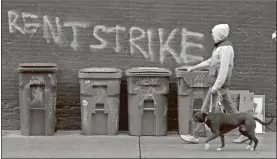  ?? AP-Ted S. Warren, File ?? A pedestrian walks past graffiti that reads “Rent Strike” in Seattle’s Capitol Hill neighborho­od. The White House announced that the Centers for Disease Control and Prevention would act under its broad powers to prevent the spread of the coronaviru­s. The measure would forbid landlords from evicting anyone for failure to pay rent, providing the renter meets criteria.