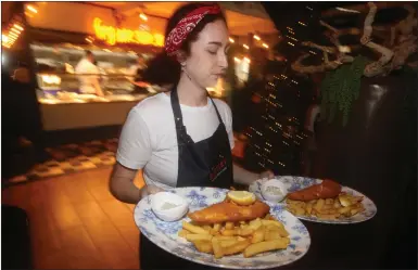  ?? Pictures: Gordon Terris ?? „ Serving up tasty meals as a waitress takes the fish and chip orders to diners.