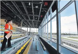  ?? CLIFFORD SKARSTEDT EXAMINER FILE PHOTO ?? Danielle Stevens watches the races from the empty grandstand on the opening night of racing at Kawartha Downs. Spectators aren’t permitted to watch live, with races streamed with online betting.