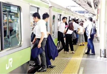  ??  ?? People get off and on a Japan Rail (JR) train at a railway station in Tokyo. Japan held a national exercise to encourage commuters to work from home in a bid to ease traffic congestion as the nation counts down three years to the 2020 Tokyo Olympics. —...