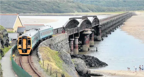  ?? Robert Parry-Jones ?? > An Arriva train crossing the railway bridge over the Mawddach Estuary, Barmouth, Gwynedd