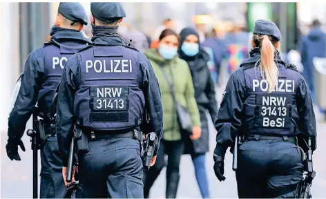  ?? FOTO: OLIVER BERG/DPA ?? Wenn einer auf Streife geht, dann kann er viel erzählen – erst recht zu Corona-Zeiten, wie hier Polizeibea­mte auf der Kölner Schilderga­sse.