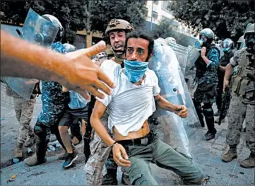  ?? THIBAULT CAMUS/AP ?? A protester is removed during a demonstrat­ion against the Lebanese government Saturday in Beirut, Lebanon.