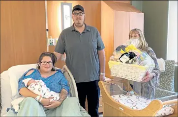  ?? East Morgan County Hospital / Courtesy photo ?? Jenisa Torralba holds new son, Oscar, with father, Trevor Schrum, in July 2020. At right, Linda Thorpe, EMCH CEO, displays the gift basket the family received for having the hospital’s 400th delivery.