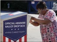  ??  ?? A voter in Athens, Ga., casts a ballot in a drop box