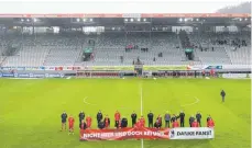  ?? FOTO: TOM WELLER/DPA ?? Mit Banner aber ohne Fans nahmen die Spieler vorläufig Abschied vom Schwarzwal­d-Stadion, in dem der SC seit 1955 spielte.