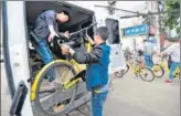  ?? XINHUA ?? Employees of a bike-sharing company clear bicycles that users improperly parked on a street near Optics Valley Square in Wuhan, Hubei province, in April.