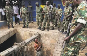  ?? Jerome Delay / Associated Press 2015 ?? A suspected member of the ruling party’s youth militia begged soldiers in 2015 to protect him from a mob of demonstrat­ors after he came out of a hiding in the capital of Bujumbura.