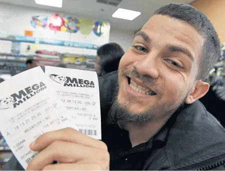  ?? PHOTOS BY JIM MICHAID / BOSTON HERALD ?? TAKING A CHANCE: Suffolk University student Travis Sean of Malden displays his two Mega Millions tickets in the 7-Eleven at Tremont and Park streets yesterday.