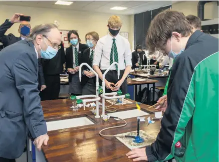  ?? LIAM MCBURNEY/ PA ?? Burning issue:
Education Minister Peter Weir during a visit to a chemistry class at Sullivan Upper School in Holywood yesterday