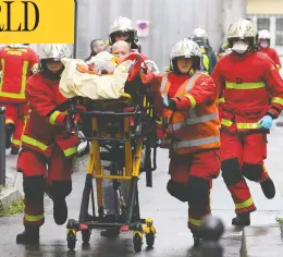  ?? ALAIN JOCARD / AFP VIA GETTY IMAGES ?? Firefighte­rs push a gurney carrying an injured person after two journalist­s were attacked in Paris on Friday near the former offices of the French satirical
magazine Charlie Hebdo. Two suspects are in police custody.