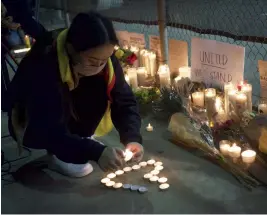  ?? (SIPA) ?? A woman lights candles at a memorial commemorat­ing the victims of the Atlanta shooting, March 2021.