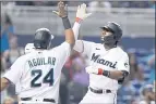  ?? LYNNE SLADKY — THE ASSOCIATED PRESS ?? Miami’s Lewis Brinson, right, is met by Jesus Aguilar after hitting a grand slam off the New York Mets’ Tylor Megill in Monday’s game.