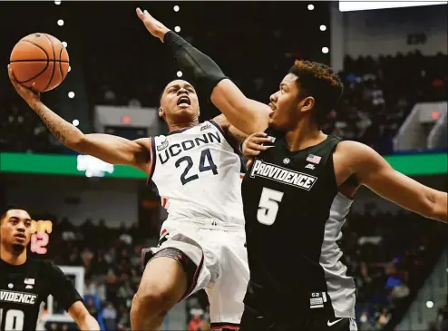  ?? Jessica Hill / Associated Press ?? UConn’s Jordan Hawkins (24) shoots while defended by Providence’s Ed Croswell on Dec. 18 at the XL Center in Hartford.