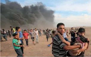  ?? AFP ?? Palestinia­ns carry a wounded protester during clashes with Israeli forces east of Gaza city, along the Gaza-Israel border. —