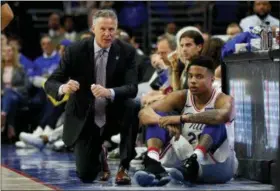  ?? CHRIS SZAGOLA — THE ASSOCIATED PRESS ?? Philadelph­ia 76ers head coach Brett Brown, left, talks with guard Markelle Fultz during Game 1 of the 76ers’ first-round playoff series against the Heat last season. Fultz will start in the 76ers’ season opener against Boston tonight.