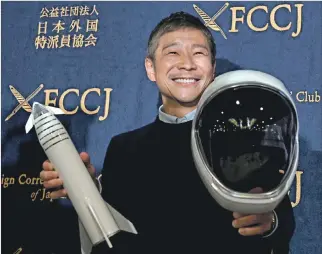  ?? TOSHIFUMI KITAMURA / AFP ?? Tokio. Yusaku Maezawa posa con un cohete en miniatura y un casco espacial ante periodista­s extranjero­s.