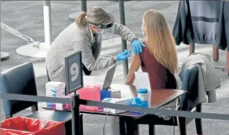  ?? MATT STONE/BOSTON HERALD ?? A patient get vaccinated at Gillette Stadium on Monday.