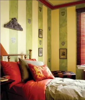  ??  ?? Stencils of ancestral shields decorate the vertical stripes in this medieval-themed bedroom.