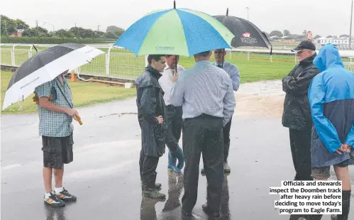  ?? ?? Officials and stewards inspect the Doomben track after heavy rain before deciding to move today’s program to Eagle Farm.