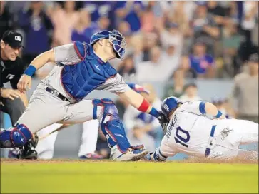  ?? Photograph­s by Allen J. Schaben Los Angeles Times ?? JUSTIN TURNER of the Dodgers is tagged out by Chris Gimenez of the Chicago Cubs while trying to score on a double by Cody Bellinger in the sixth inning as umpire Angel Hernandez is set to make the call.