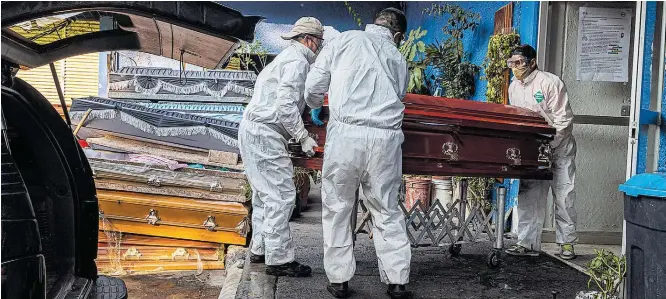  ?? DANIEL BEREHULAK/THE NEW YORK TIMES ?? Realidade. Trabalhado­res carregam caixão de vítima da covid-19 para ser cremado em cemitério da Cidade do México, onde em alguns hospitais os pacientes ficam dias deitados no chão