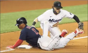  ?? Michael Reaves / Getty Images ?? The Red Sox’s Rafael Devers safely slides into third base past the tag of the Marlins’ Brian Anderson during the eighth inning Tuesday.