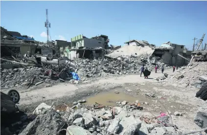  ?? AFP ?? Iraqis inspect the damage in Mosul’s Al Jadida area yesterday, following air strikes in an ongoing offensive against ISIL. Baghdad is investigat­ing the large number of civilian deaths in west Mosul recent days, a military spokesman said.