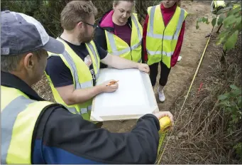  ??  ?? David McIlreavy instructs how to enlarge the trench opened behind the church to investigat­e the enclosure suggested by the name Raithín.