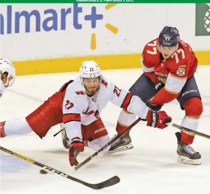  ?? CHARLES TRAINOR JR ctrainor@miamiheral­d.com ?? The Panthers’ Frank Vatrano scores in the third period as his stick goes underneath Hurricanes defenseman Brett Pesce on Monday night at the BB&T Center. It was Vatrano’s seventh goal of the season.