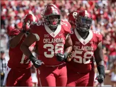  ??  ?? In this Oct. 7 photo, Oklahoma fullback Dimitri Flowers (center) celebrates a touchdown with teammate Erick Wren (right) during an NCAA college football game against Iowa State in Norman, Okla. AP PHOTO