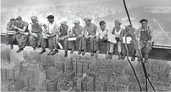  ??  ?? New York iron workers take a perilous lunch break high atop the then RCA building in a photograph that has become iconic for the US labour movement.