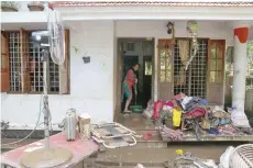  ?? — Reuters ?? A woman cleans the mud from the entrance of her house following floods in Paravur on Tuesday.