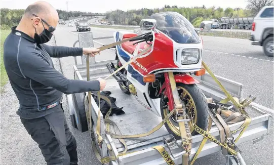  ??  ?? David Booth loads up his prized 1982 Honda CB1100RC on Charles Snell’s trailer.