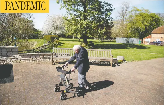  ?? PETER CZIBORRA / REUTERS ?? Retired British Army captain Tom Moore, 99, raises money for health-care workers by attempting to walk the length of his garden 100 times before his 100th birthday this month.