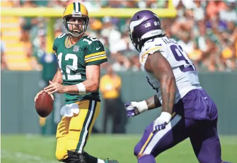  ?? GETTY IMAGES ?? Aaron Rodgers rolls out to pass during the third quarter. Though injured, Rodgers showed he could move in and and out of the pocket on Sunday.