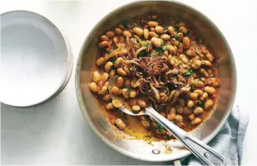  ?? DAVID MALOSH/THE NEW YORK TIMES ?? Canned cannellini beans braised with olive oil, rosemary, tomato and golden fried onions make the best of your pantry.