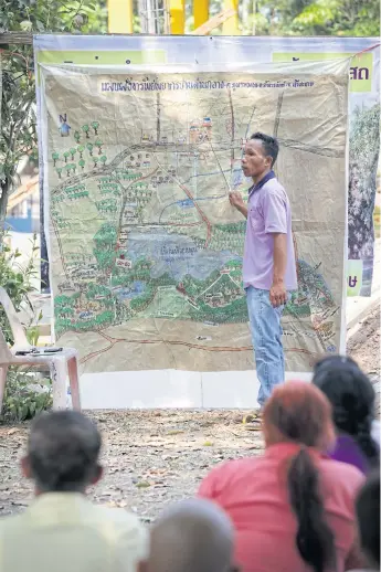  ??  ?? YOU ARE HERE: Suthien Piewjan, 37, shows a cultural map of Ban Dan village in Si Sa Ket.