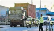  ?? AFP ?? Police officers escort an army truck carrying a freight container laden with the car of Sergei Skripal in Salisbury.