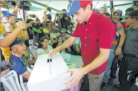  ?? ARIANA CUBILLOS / AP ?? Opposition leader Henrique Capriles casts his ballot during a symbolic referendum in Caracas, Venezuela, on Sunday. Participat­ion appeared to be high, with large crowds of people lining up at tables in churches and parks across the capital.