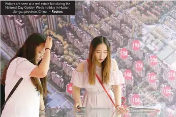  ?? — Reuters ?? Visitors are seen at a real estate fair during the National Day Golden Week holiday in Huaian, Jiangsu province, China.