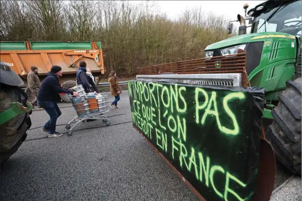  ?? ?? Med deres traktorer blokerer franske landmaend motorvejen A16. Foto: Yves Herman/Reuters