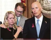  ?? Mark Wallheiser / Associated Press ?? Jennifer Montalto and Ryan Petty, who both lost teens in the Florida massacre, stand with Gov. Rick Scott, who broke with the NRA, signing a gun bill.