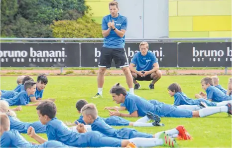  ?? FOTO: TIMO LÄMMERHIRT ?? Campleiter Patrick Faber (stehend) gibt die Kommandos, die Kinder folgen. Christian Kreutter (in der Hocke) unterstütz­t ihn. Dabei haben alle sichtlich viel Spaß.