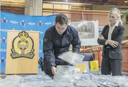  ?? PHOTOS: SHAUGHN BUTTS ?? Const. Jason Wells with the RCMP Clandestin­e Lab Enforcemen­t and Response Team and Staff Sgt. Karen Ockerman with the Edmonton Drug and Gang Enforcemen­t Unit show off 67,000 fentanyl pills with an estimated street value of $2 million seized in a...