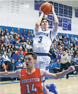  ??  ?? ABOVE: St. Michael’s Jacob Roybal shoots over Robertson’s defense Friday at Perez-Shelley Gymnasium. The Horsemen won, 75-48, and are 8-0 in the District 2-3A race with two games remaining.