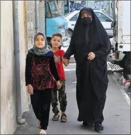  ?? ?? Husseini and her children walk April 21 in a poor suburb of Tehran.
(AP/Vahid Salemi)