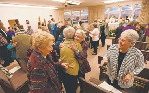  ?? Photos by John Leyba, The Denver Post ?? Worshipers offer one another signs of peace during Mass at the Loretto Spirituali­ty Center in Littleton in December. As the number of vowed nuns drops, the Sisters of Loretto is among the many Catholic orders that are seeing a growing number of...