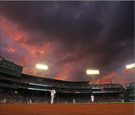  ?? STAFF PHOTO — MATT STONE/ BOSTON HERALD ?? A sunset reflects on the clouds after a downpour at Fenway Park during the second inning of a MLB game between the Boston Red Sox and New York Yankees at Fenway Park on Aug. 2, 2018.