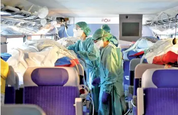  ?? — AFP photo ?? French nurses take care of four patients infected with the novel coronaviru­s (Covid-19) in a medicalise­d TGV (highspeed train) at Nancy train station as 24 patients from Nancy and Metz are being transfered from Nancy and Metz towards Bordeaux, Libourne, Pau and Bayonne.